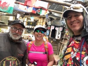Peregrinos dentro del albergue de Manjarín en el Camino Francés, con banderas y símbolos templarios al fondo.