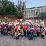 Grupo de peregrinos posando frente a un letrero en el Camino Francés.
