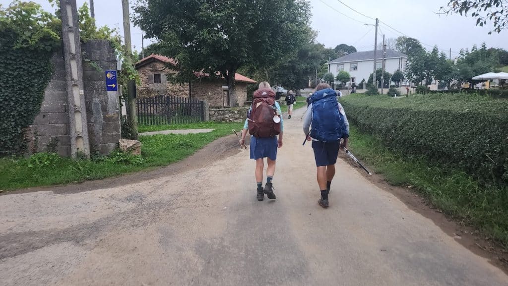 Peregrinos caminando en una de las rutas del Camino de Santiago, rodeados de paisajes naturales y con mochilas ligeras. que es el camino de santiago